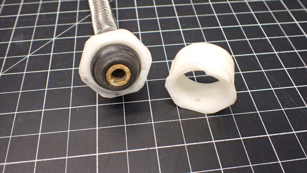 This coupling nut fractured and split into two pieces, and a thorough examination revealed evidence of the primary cause of failure.