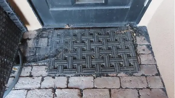 Small particles of charred material, like this in this outdoor entryway, may originate on the property or be borne there by the wind – which can still indicate how the fire impacted the house.
