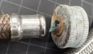 A stray current from the washing machine’s thermistor accelerated the corrosion of this water hose fitting.