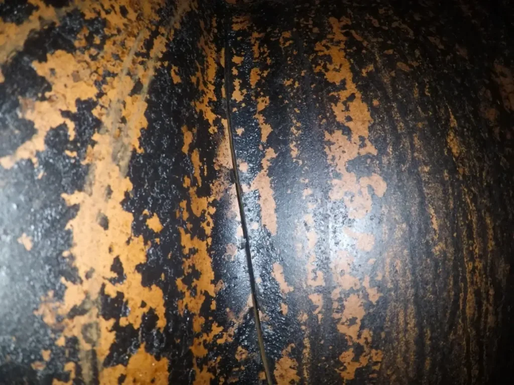 The vertical crack in this tile flue and the presence of burnt creosote indicate a chimney fire may have occurred.