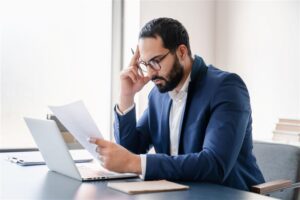 A man in a suit examines a document