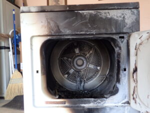 Fire-damaged clothes dryer with burn damage in and around the drum